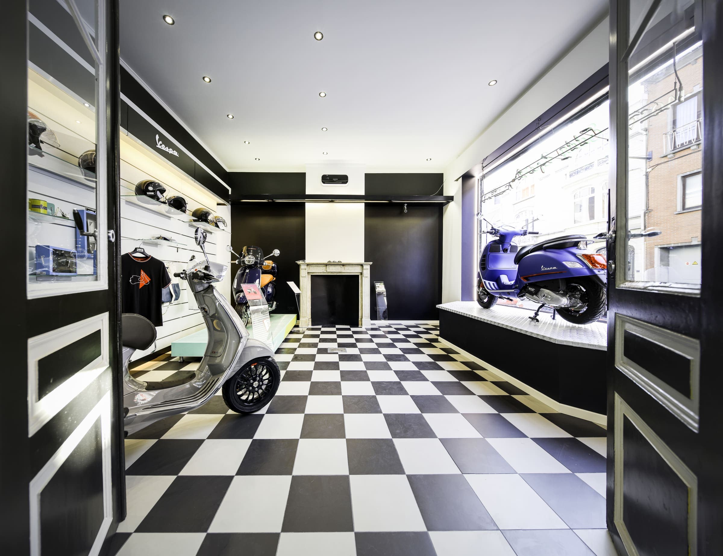 De showroom van Eddy Sport, Vespa-scooters op een zwart-wit dambordvloer